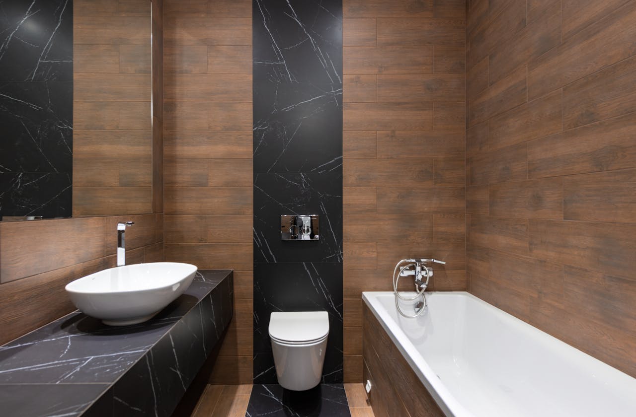 about-02 Sleek modern bathroom featuring wood paneling and marble accents, with a white basin and bathtub.